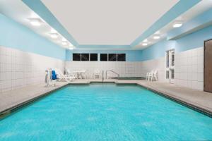 uma piscina com água azul num edifício em Microtel Inn & Suites by Wyndham New Ulm em New Ulm