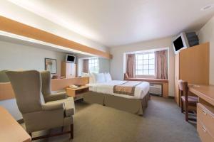 Habitación de hotel con cama y silla en Microtel Inn & Suites by Wyndham Altus en Altus