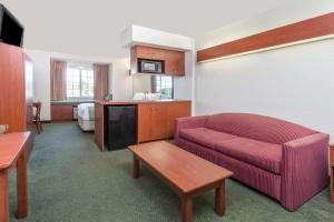 a living room with a couch and a tv in a room at Microtel Inn & Suites Marianna in Marianna