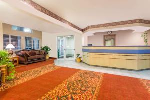 sala de estar con sofá y alfombra en Boarders Inn & Suites by Cobblestone Hotels - Brush, en Brush