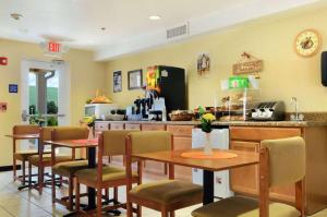 restauracja z dwoma stołami i krzesłami oraz ladą w obiekcie Microtel Inn & Suites Huntsville w mieście Huntsville