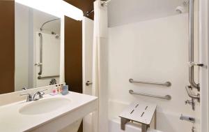 a white bathroom with a sink and a mirror at Wingate by Wyndham Destin in Destin