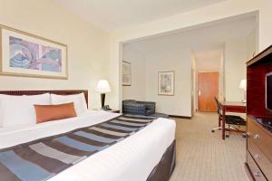 a hotel room with a large bed and a desk at Wingate by Wyndham Destin in Destin