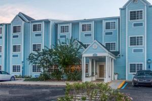un edificio azul con un coche aparcado delante de él en Microtel Inn & Suites by Wyndham Port Charlotte Punta Gorda en Port Charlotte