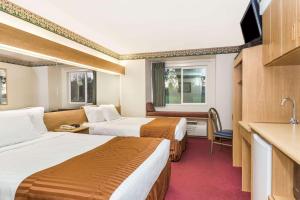 Habitación de hotel con 2 camas y cocina en Boarders Inn & Suites by Cobblestone Hotels - Brush, en Brush