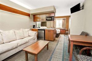 a living room with a couch and a kitchen at Microtel Inn & Suites by Wyndham Mason in Mason