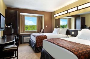 マリエッタにあるMicrotel Inn & Suites by Wyndham Mariettaのベッド2台とデスクが備わるホテルルームです。