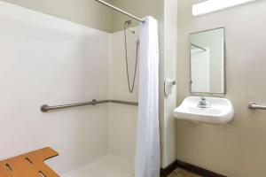 
a bathroom with a shower, sink, and mirror at Microtel Inn & Suites by Wyndham Tuscaloosa in Tuscaloosa
