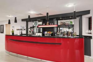 a red bar in a restaurant with a counter at Ramada Encore Newcastle-Gateshead in Newcastle upon Tyne