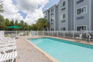a swimming pool in front of a building at Microtel Inn & Suites by Wyndham Spring Hill/Weeki Wachee in Weeki Wachee