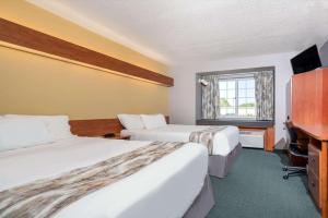 una camera d'albergo con due letti e una televisione di Microtel Inn & Suites by Wyndham New Ulm a New Ulm