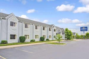 a large white building with a sign in a parking lot at Microtel Inn & Suites by Wyndham Mason in Mason