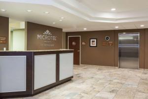 a lobby of a microsoft office building with a reception counter at Microtel Inn & Suites by Wyndham Wheeler Ridge in Wheeler Ridge