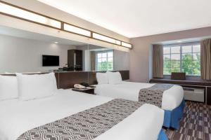 Habitación de hotel con 2 camas y TV de pantalla plana. en Microtel Inn & Suites by Wyndham Tuscaloosa, en Tuscaloosa