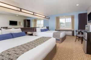 a hotel room with two beds and a desk at Microtel Inn & Suites by Wyndham Klamath Falls in Klamath Falls