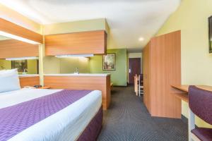 a hotel room with a bed and a kitchen at Microtel Inn & Suites by Wyndham Auburn in Auburn