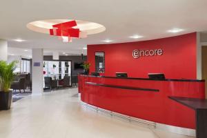 un vestíbulo de una oficina con una pared roja en Ramada Encore Newcastle-Gateshead en Newcastle