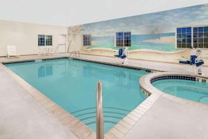 a large swimming pool with a painting on the wall at Microtel Inn & Suites in Sidney