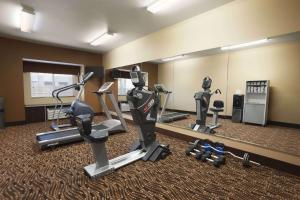 einen Fitnessraum mit Laufbändern und einem Spiegel in der Unterkunft Microtel Inn & Suites by Wyndham Odessa TX in Odessa