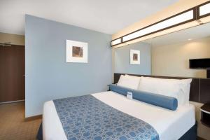 A bed or beds in a room at Microtel Inn & Suites by Wyndham Stanley