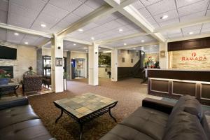 a lobby with a couch and a table in a room at Ramada by Wyndham Lethbridge in Lethbridge