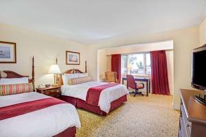 a hotel room with two beds and a flat screen tv at Ramada by Wyndham Seekonk Providence Area in Seekonk