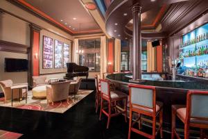 a bar with chairs and a piano in a room at The George Washington - A Wyndham Grand Hotel in Winchester
