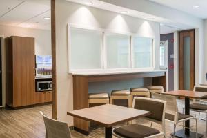 Microtel Inn & Suites by Wyndham Altoona في ألتونا: غرفة طعام مع طاولات وكراسي ومطبخ