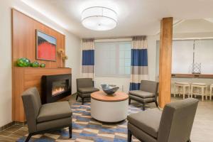 sala de estar con sillas y chimenea en Microtel Inn & Suites by Wyndham Altoona en Altoona