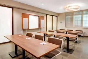 une salle de conférence avec des tables et des chaises en bois dans l'établissement Microtel Inn & Suites by Wyndham Philadelphia Airport Ridley Park, à Ridley Park