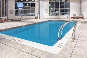 a swimming pool in a building with blue water at Microtel Inn & Suites by Wyndham Kirkland Lake in Kirkland Lake