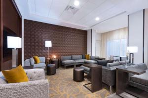 a hotel lobby with couches and tables and yellow pillows at Wingate by Wyndham Sidney in Sidney