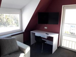 a room with a desk with a tv and a couch at Topolowa in Zgierz