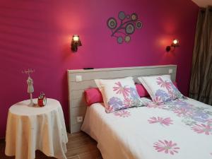 1 dormitorio con paredes moradas y 1 cama con mesa en Gîte du Toilier, en Thillot-sous-les-Côtes