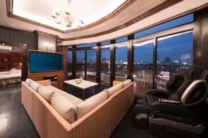 a living room with a couch and a television at Hotel Alps in Osaka