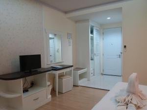 a white room with a television and a desk with a computer at Kradang Nga Boutique Inn in Khun Han