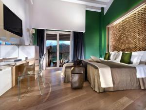 a bedroom with a large bed and a green wall at Bouganville Hill Resort & Wellness Space in Picerno