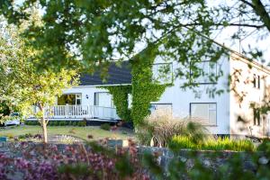 Casa blanca con porche y patio en The Waterfront House Country Home, en Oughterard