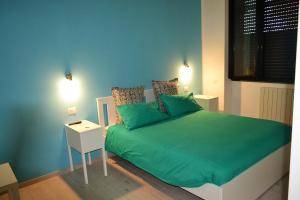 a bedroom with a green bed with a night stand at Villa Arechi in Salerno