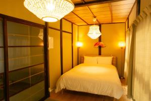 京都市にあるHoly's Houseのベッドルーム(白いベッド1台、シャンデリア付)
