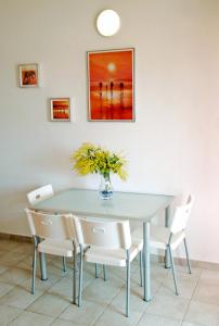 a dining room table with chairs and a vase of flowers at Casa ARCU DE CHELU in Santa Lucia +25 photos