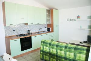 a kitchen with white cabinets and a stove top oven at Casa ARCU DE CHELU in Santa Lucia