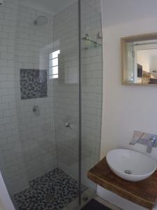 a bathroom with a glass shower with a sink at 41 on Serruria in Stellenbosch