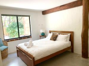 a bedroom with a large bed with a window at By the Sea Margaret River in Gnarabup