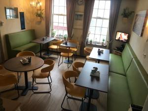 a restaurant with tables and chairs and windows at Pension de Zeeschelp in Domburg