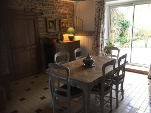 jadalnia ze stołem i krzesłami oraz oknem w obiekcie Chez Mémère Hélène w mieście Sormonne