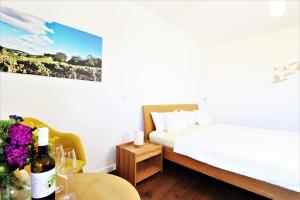 a bedroom with a bed and a table with a bottle of wine at BioWeingut & Landhotel Gänz in Hackenheim
