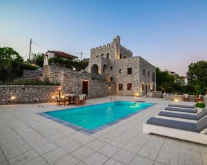 a house with a swimming pool in front of a building at Cassiopeia's Castle in Gythio