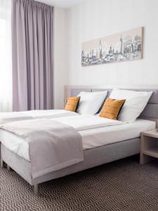 um quarto com uma cama grande com almofadas brancas e amarelas em Hotel Chrobrego9 em Bolesławiec