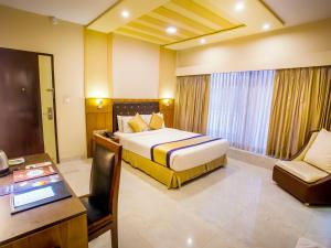a hotel room with a bed and a desk and a chair at Asia Hotel & Resorts in Dhaka